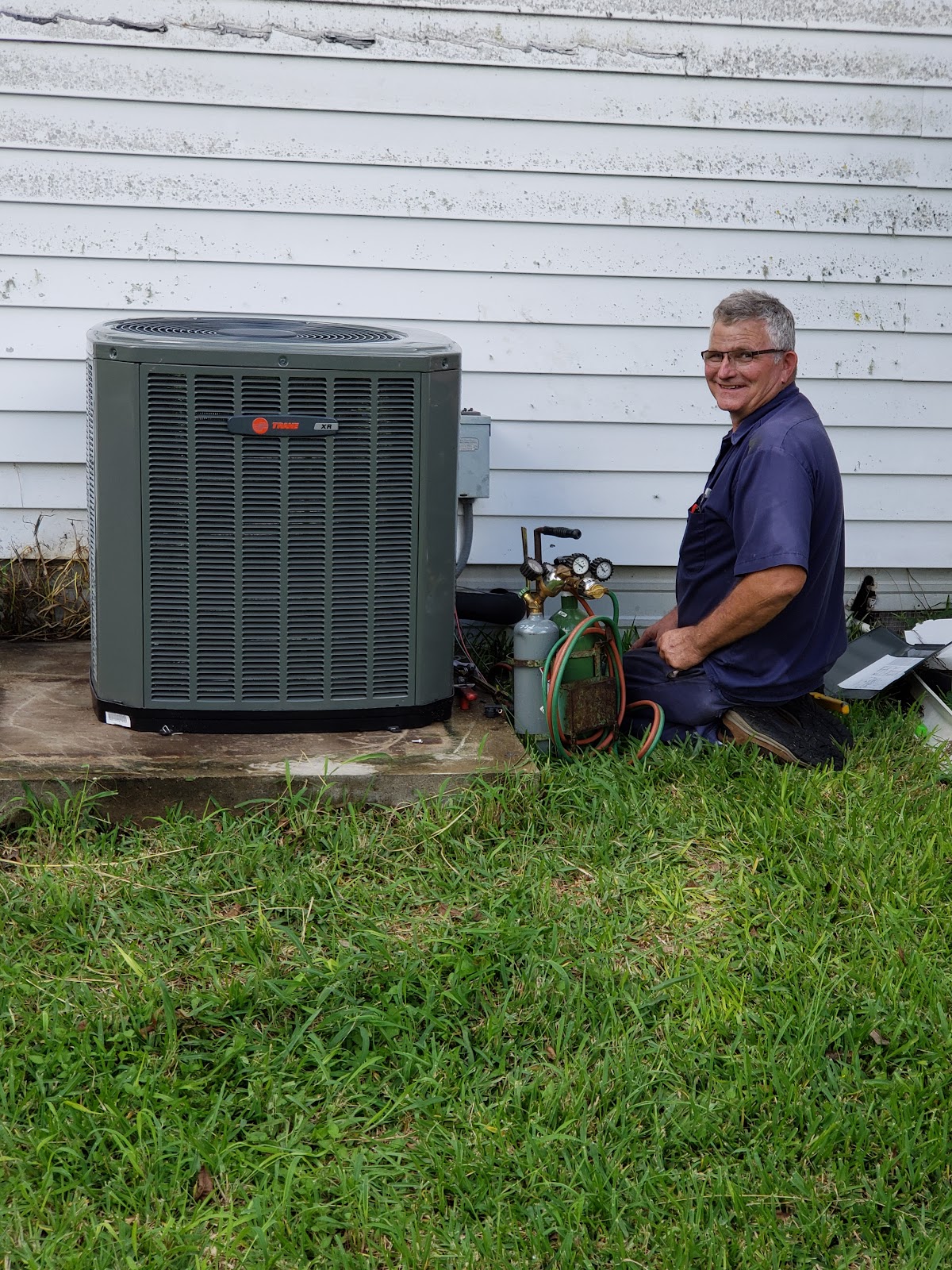 All Seasons technician beside a newly installed Trane outdoor unit in Beeville